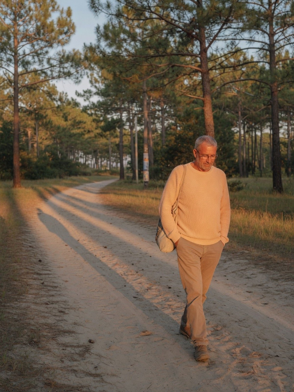 Homme marchant sur un chemin parmi les pins